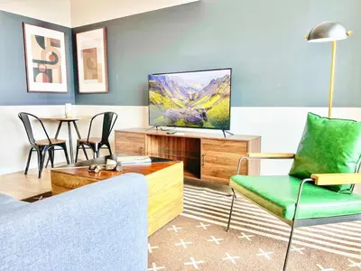 a living room with a couch and a tv at Sunset Stay in Downtown San Diego in San Diego