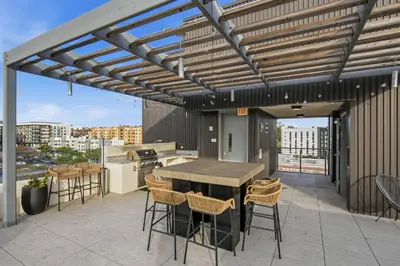 a patio with a table and chairs on a roof at Sunset Stay in Downtown San Diego in San Diego