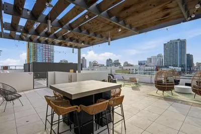a patio with a table and chairs on a roof at Sunset Stay in Downtown San Diego in San Diego