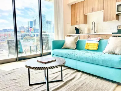a living room with a blue couch and a table at Beautiful One Bedroom Apartment With View of City in San Diego