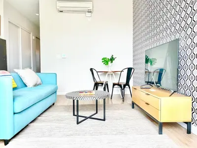 a living room with a blue couch and a table at Beautiful One Bedroom Apartment With View of City in San Diego