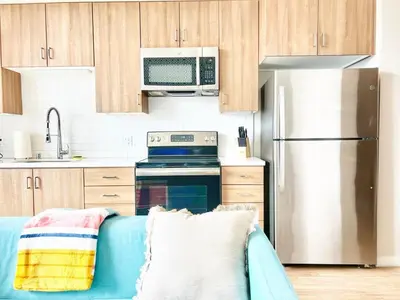 a kitchen with a blue couch in front of a refrigerator at Beautiful One Bedroom Apartment With View of City in San Diego