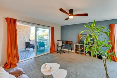 a living room with a ceiling fan and a plant at Quiet San Diego Condo with Balcony, Pool and Hot Tub! in San Diego