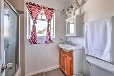 a bathroom with a sink and a toilet and a window at Mtn-View Home Less Than 1 Mi to Lake Elsinore! in Lake Elsinore