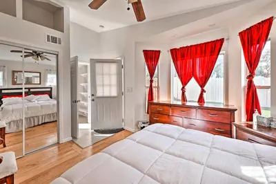 a bedroom with a large bed and red curtains at Mtn-View Home Less Than 1 Mi to Lake Elsinore! in Lake Elsinore