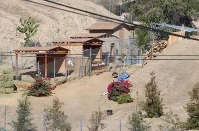 a house is being built on a hill with flowers at Mountain View Studio in Hemet