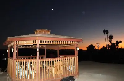 a large wooden gazebo with white chairs in it at Mountain View Studio in Hemet