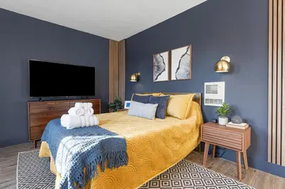 a bedroom with a large bed and a flat screen tv at Modern National City Studio in National City