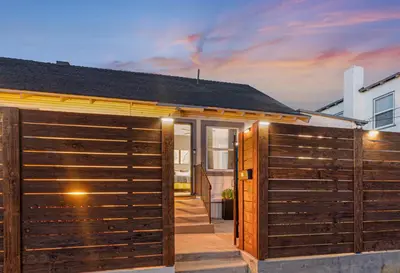 a house with a wooden fence in front of it at Modern National City Studio in National City
