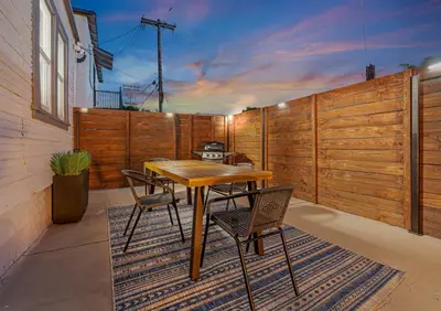 a patio with a wooden fence and a table and chairs at Modern National City Studio in National City