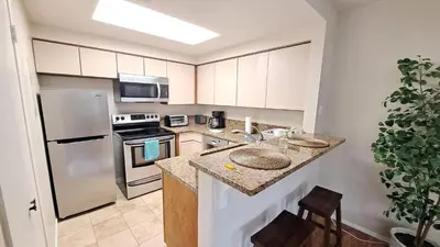 a kitchen with white cabinets and a counter top at -Vacation-Top corner 2-story one bedroom La Jolla Condo in San Diego