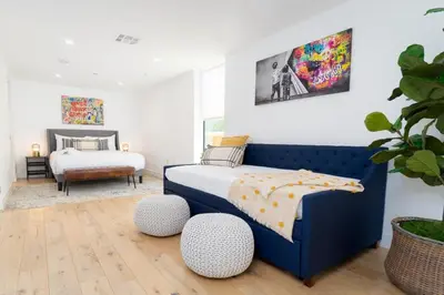 a bedroom with a blue bed and a bedroom with a bedskirts at Bright and Trendy - Panoramic - Chic - Prime Location in San Diego