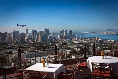 two tables and chairs on a balcony with a view of the city at Bright and Trendy - Panoramic - Chic - Prime Location in San Diego