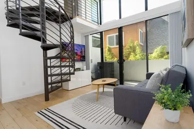 a living room with a spiral staircase and a couch at Bright and Trendy - Panoramic - Chic - Prime Location in San Diego