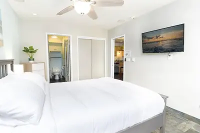 a white bedroom with a bed and a ceiling fan at Pineapple Paradise - Mission Beach - Stunning in San Diego