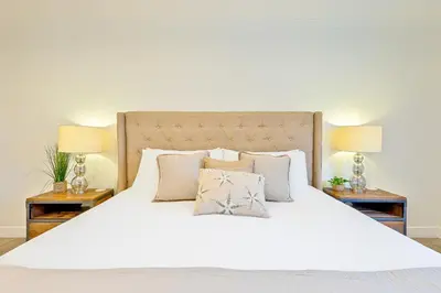a large white bed with two lamps on two tables at La Jolla Beach Retreat Compound in San Diego