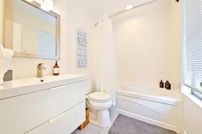 a white bathroom with a sink and a toilet at La Jolla Beach Retreat Compound in San Diego