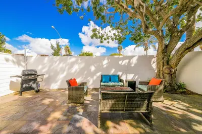 a patio with chairs and a grill and a tree at La Jolla Beach Retreat Compound in San Diego