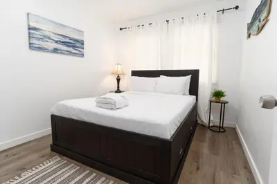 a bedroom with a large bed with white sheets at Nautical Point Loma Getaway - 7 mins to airport in San Diego