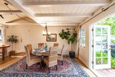 a dining room with a table and chairs on a rug at Charming La Jolla Shores Cottage in San Diego