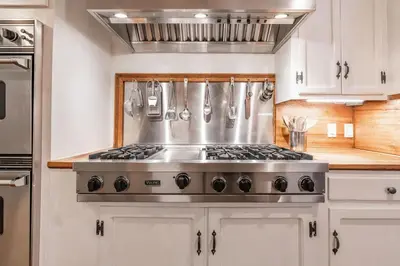 a stove top in a kitchen with white cabinets at Charming La Jolla Shores Cottage in San Diego