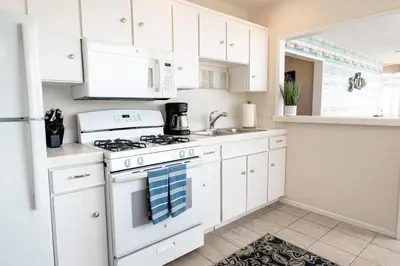 a white kitchen with a stove and a sink at CB-2445B - Carlsbad Casa De Los Sueños | Unit B in Carlsbad