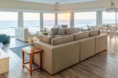 a living room with a large couch and the ocean at CB-2445D - Located on the Sand- Casa De Los Suenos in Carlsbad
