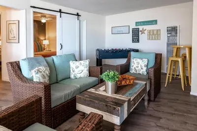 a living room with a couch and a table at CB-2445D - Located on the Sand- Casa De Los Suenos in Carlsbad