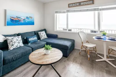 a living room with a couch and a table at CB-2445D - Located on the Sand- Casa De Los Suenos in Carlsbad