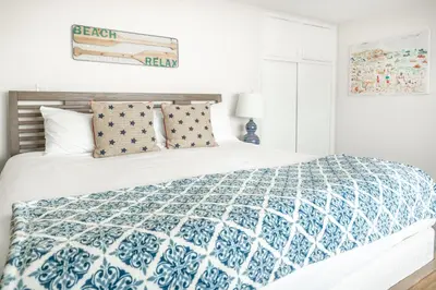 a bedroom with a bed with a blue and white comforter at CB-2445D - Located on the Sand- Casa De Los Suenos in Carlsbad