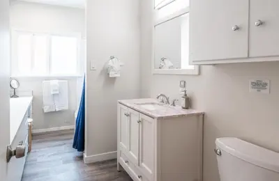 a white bathroom with a sink and a toilet at CB-2445D - Located on the Sand- Casa De Los Suenos in Carlsbad