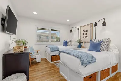 a bedroom with two beds and a tv in it at SB-767D - Soothing Solana Oceanfront Condo in Solana Beach