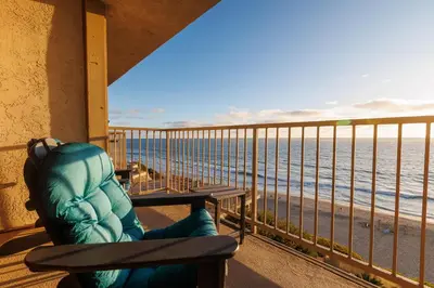 a person sitting on a bench looking at the ocean at SB-767D - Soothing Solana Oceanfront Condo in Solana Beach