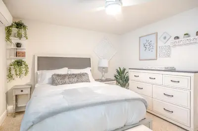 a bedroom with a white bed and a white dresser at Stunning Oceanfront Home - Incredible Views in Oceanside