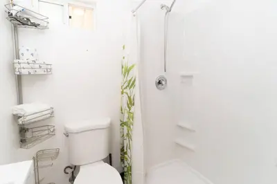 a white bathroom with a toilet and a shower at Studio Bungalow in the Heart of Normal Heights in San Diego