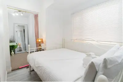 a white bedroom with a white bed and a window at Studio Bungalow in the Heart of Normal Heights in San Diego
