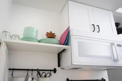 a kitchen with white cabinets and a microwave at Studio Bungalow in the Heart of Normal Heights in San Diego