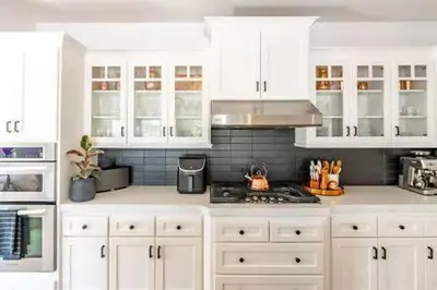 a white kitchen with white cabinets and a stove at Carlsbad Dream House with Hot Tub Walk to Beach in Carlsbad