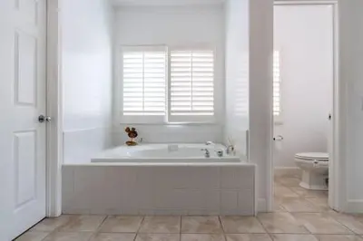 a white bathroom with a tub and a toilet at Carlsbad Dream House with Hot Tub Walk to Beach in Carlsbad
