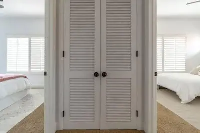 a bedroom with white closet doors and a bed at Carlsbad Dream House with Hot Tub Walk to Beach in Carlsbad
