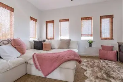 a living room with a white couch and windows at Carlsbad Dream House with Hot Tub Walk to Beach in Carlsbad