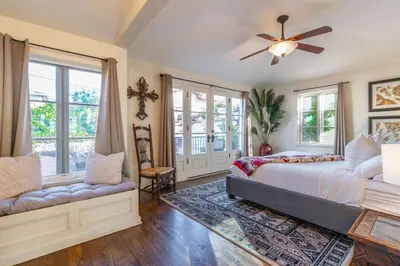 a bedroom with a bed and a fan and windows at Ocean View Spanish Beauty Half Block to Beach in San Diego