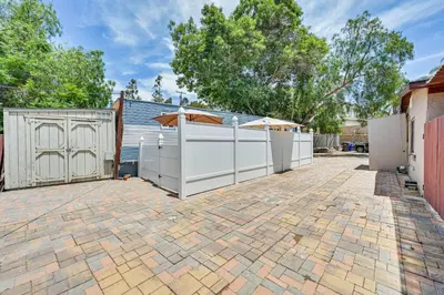 a backyard with a white fence and a brick driveway at Low-Key Poway Home about 20 Mi to La Jolla and San Diego in Poway