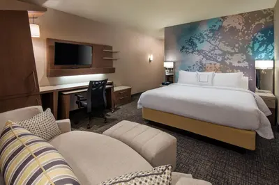 a hotel room with a bed and a desk and a tv at Courtyard by Marriott Irvine Spectrum in Irvine