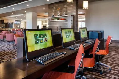 a row of computers sitting on a table with chairs at Courtyard by Marriott Irvine Spectrum in Irvine