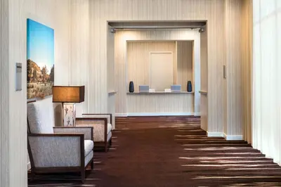 a hallway of a hotel with chairs and a mirror at Courtyard by Marriott Irvine Spectrum in Irvine