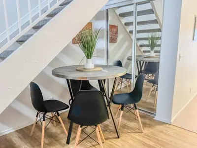 a table and chairs in a room with stairs at Charming 2nd Ave Lofts in Downtown San Diego with Parking in San Diego