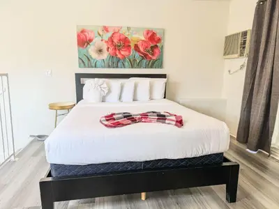 a bedroom with a white bed with red flowers on the wall at Charming 2nd Ave Lofts in Downtown San Diego with Parking in San Diego