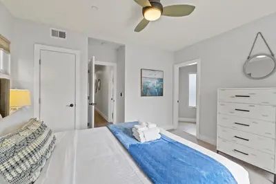 a white bedroom with a bed with a blue blanket at Pacific Beach Paradise by Cardo -Spacious Retreat in San Diego