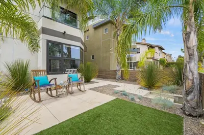 a backyard with two chairs and palm trees at Pacific Beach Paradise by Cardo -Spacious Retreat in San Diego